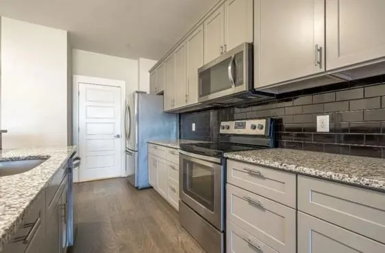 a kitchen with stainless steel appliances granite countertop a sink stove and refrigerator
