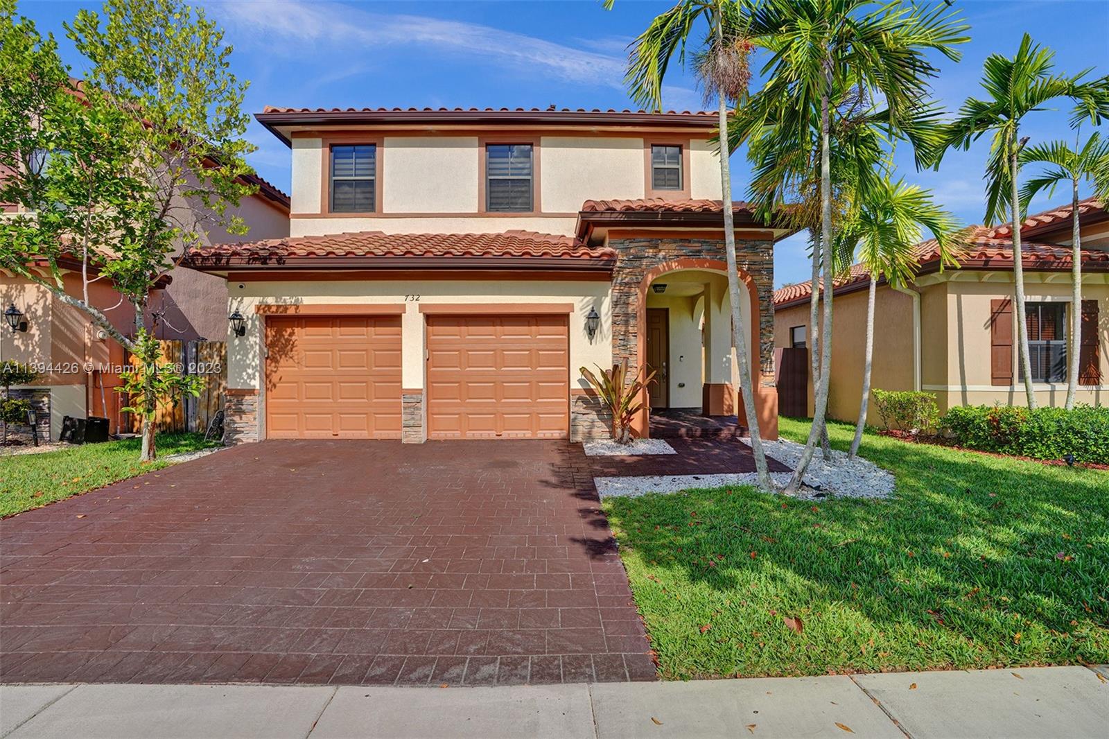 a view of a house with a yard and palm trees