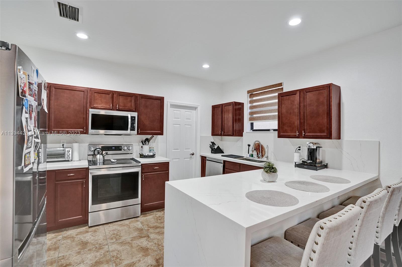 732 Southeast 33 Terrace Homestead, FL 33033 - Photo 20 of 65 a kitchen with stainless steel appliances granite countertop a sink stove and microwave