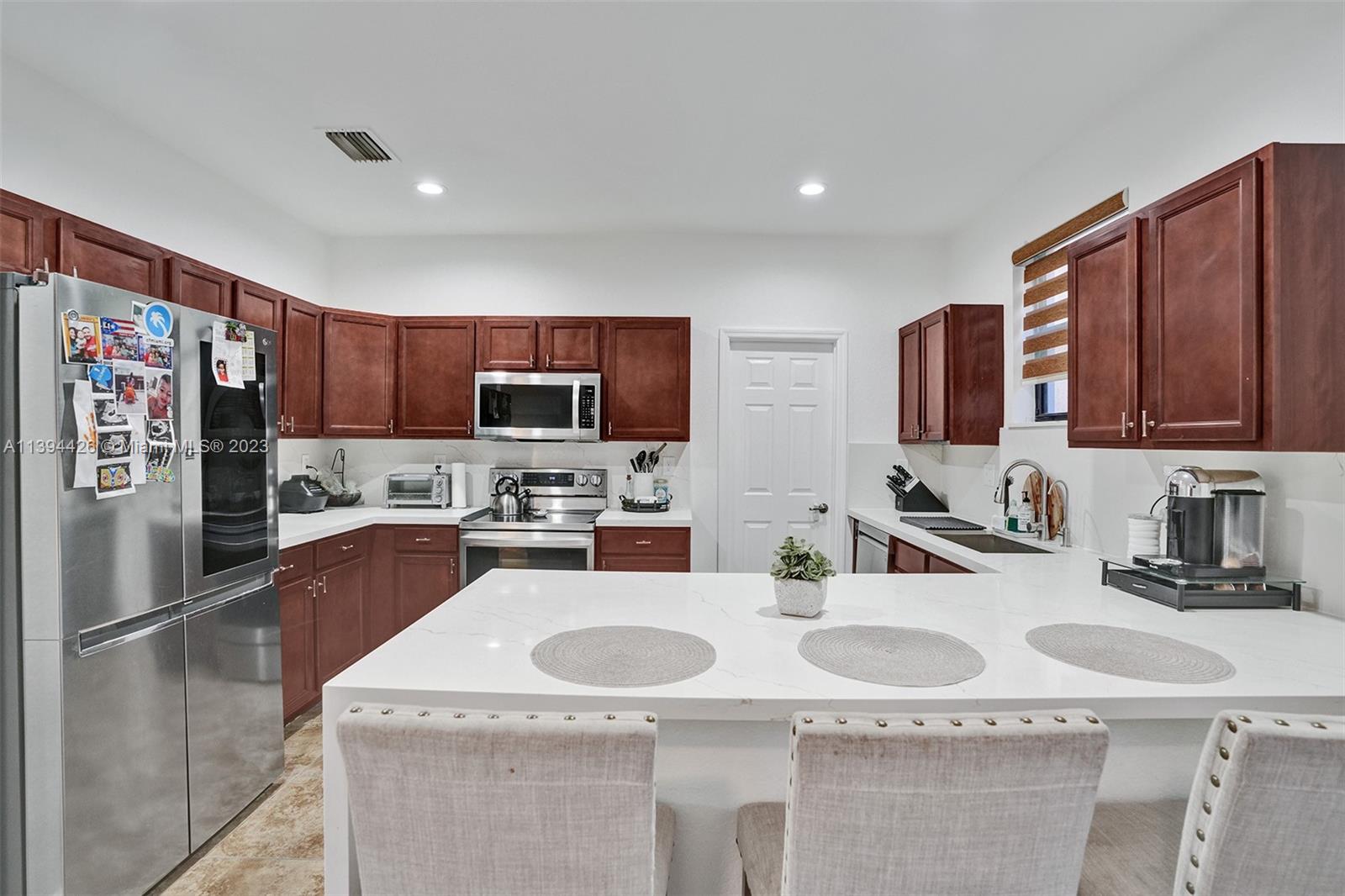 732 Southeast 33 Terrace Homestead, FL 33033 - Photo 21 of 65 a kitchen with stainless steel appliances granite countertop a sink refrigerator and microwave