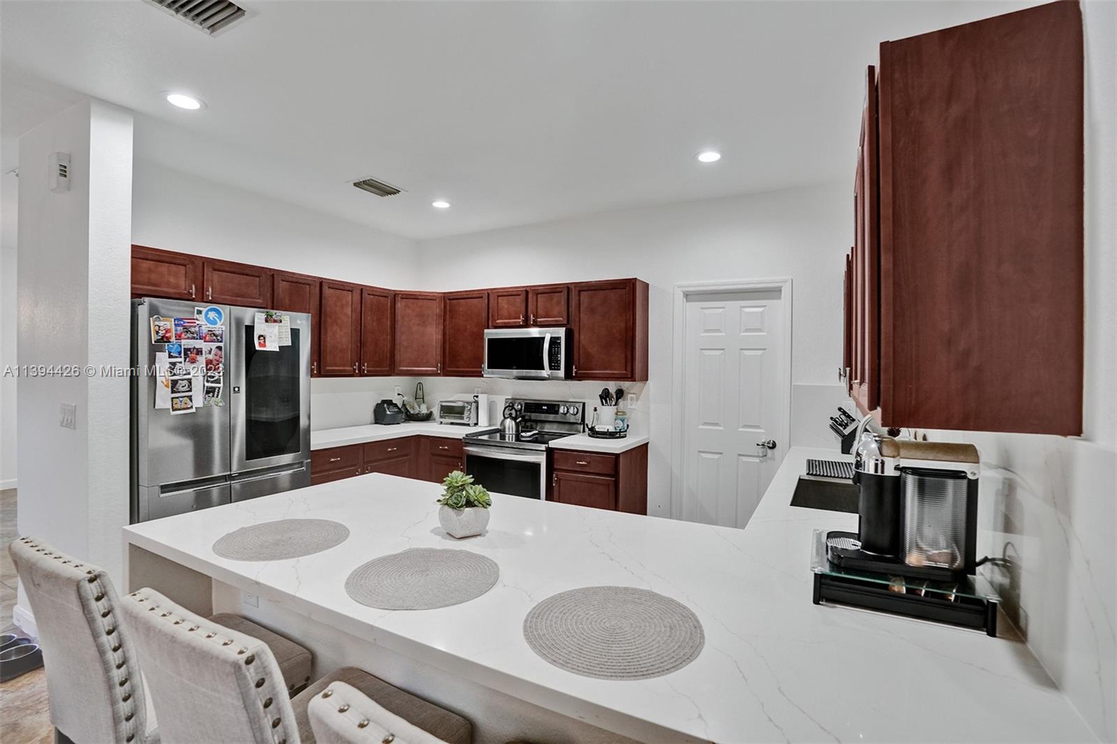 732 Southeast 33 Terrace Homestead, FL 33033 - Photo 22 of 65 a kitchen with a sink a stove and chairs