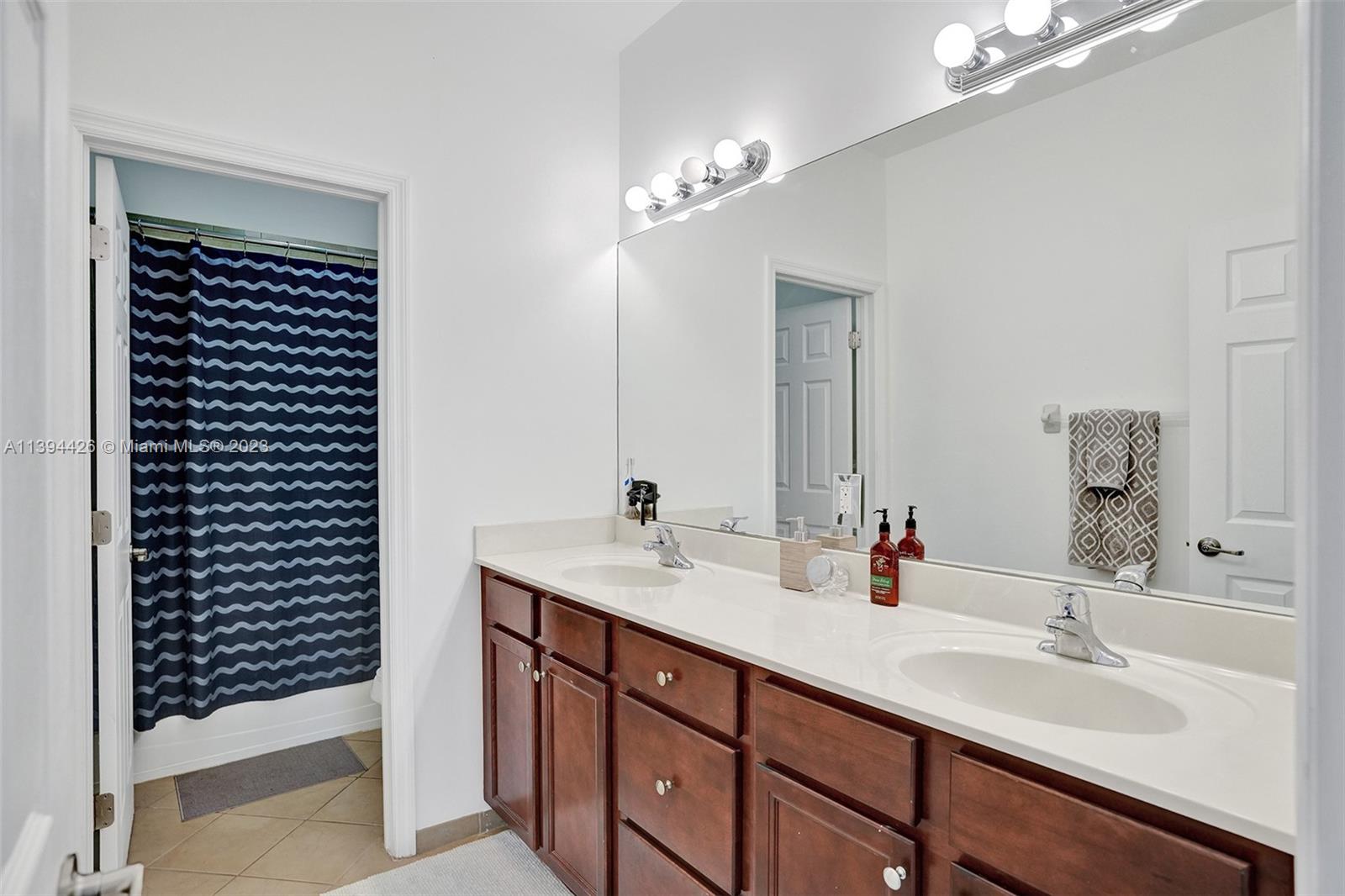 732 Southeast 33 Terrace Homestead, FL 33033 - Photo 36 of 65 a bathroom with a double vanity sink and a mirror