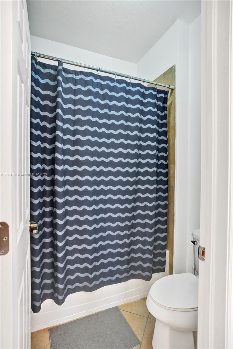 732 Southeast 33 Terrace Homestead, FL 33033 - Photo 37 of 65 a bathroom with a toilet and a shower curtain