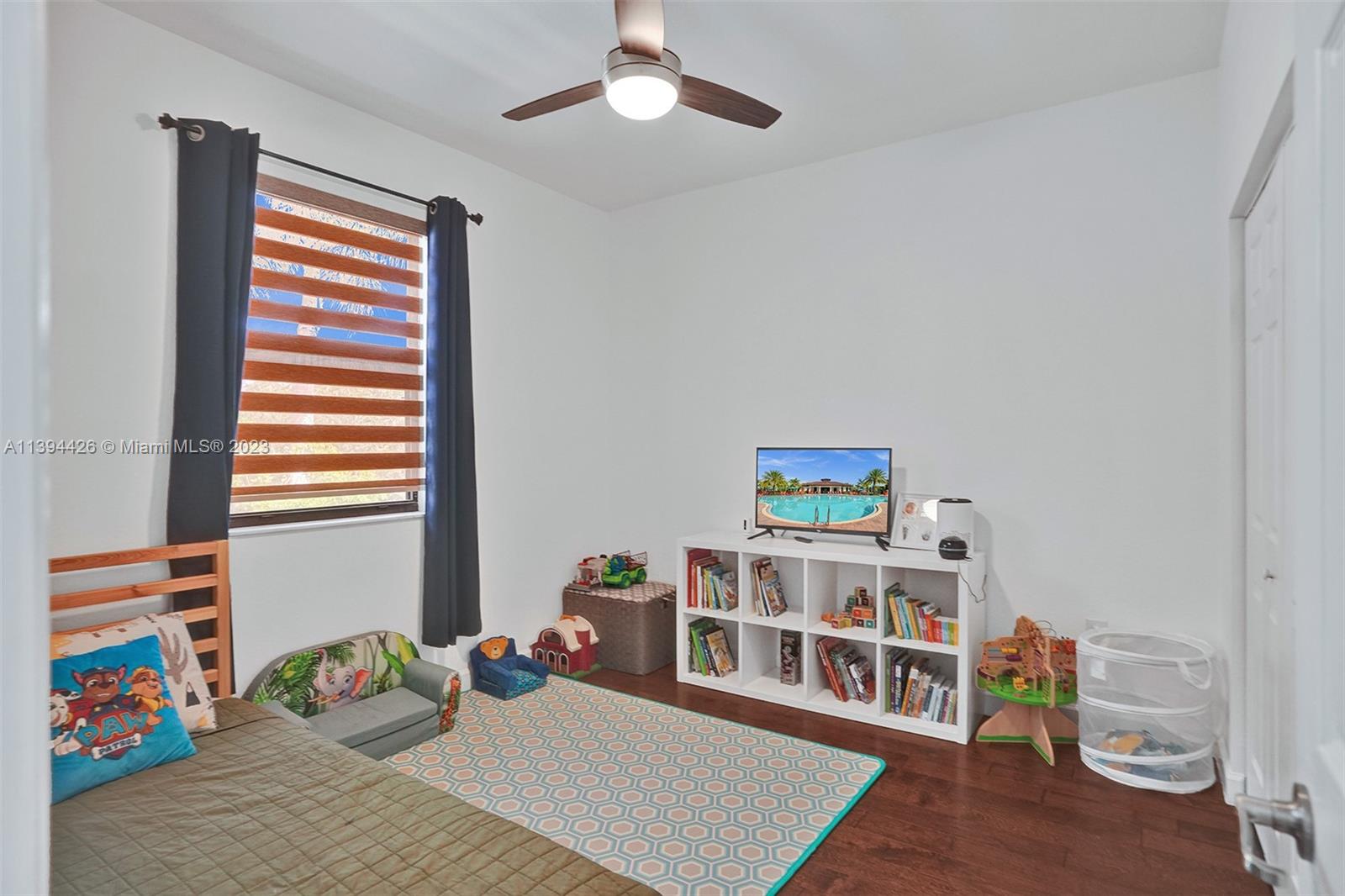 732 Southeast 33 Terrace Homestead, FL 33033 - Photo 42 of 65 a bedroom with furniture and a book shelf