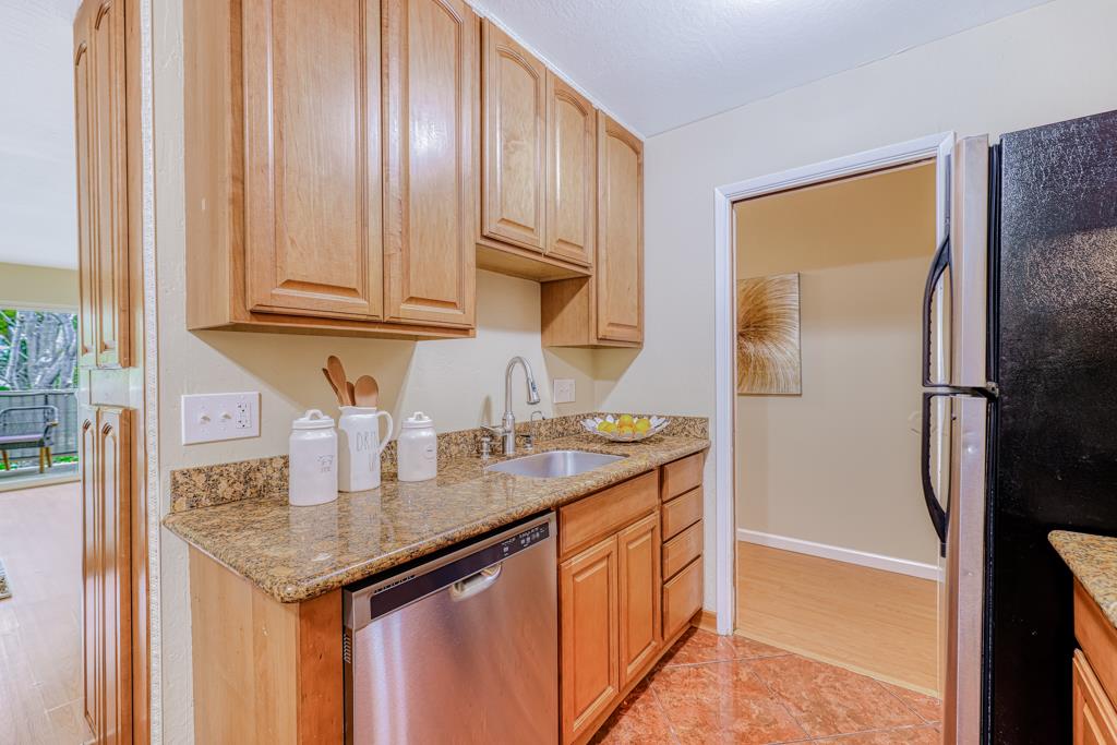 38455 Bronson Street, Unit 322 Fremont, CA 94536 - Photo 12 of 35 a kitchen with stainless steel appliances granite countertop a sink and a refrigerator