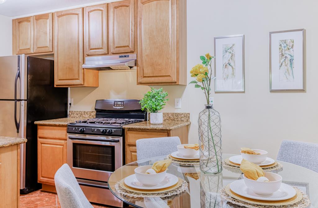 38455 Bronson Street, Unit 322 Fremont, CA 94536 - Photo 7 of 35 a kitchen with stainless steel appliances granite countertop a stove a sink and a refrigerator