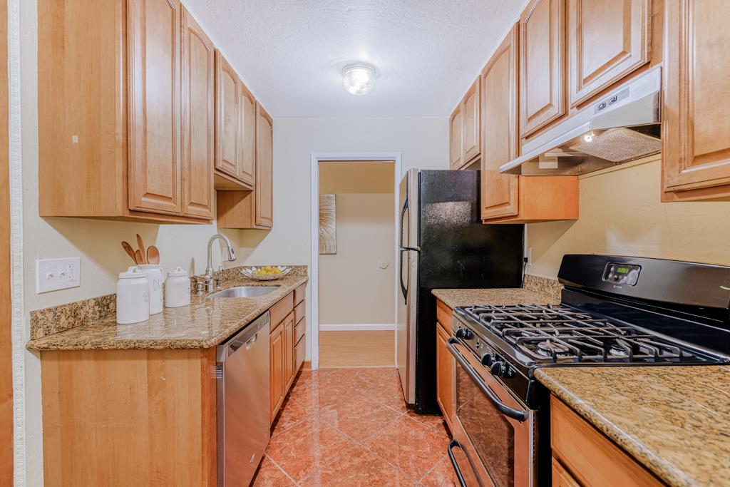 38455 Bronson Street, Unit 322 Fremont, CA 94536 - Photo 8 of 35 a kitchen with granite countertop a sink stove and refrigerator