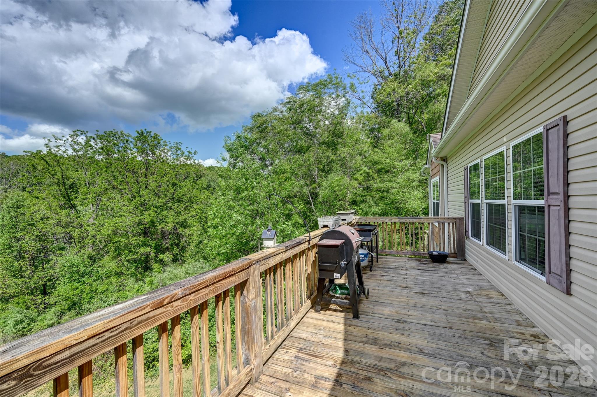 371 Starnes Cove Road Candler, NC 28715 - Photo 19 of 21 a balcony with wooden floor and trees in the back
