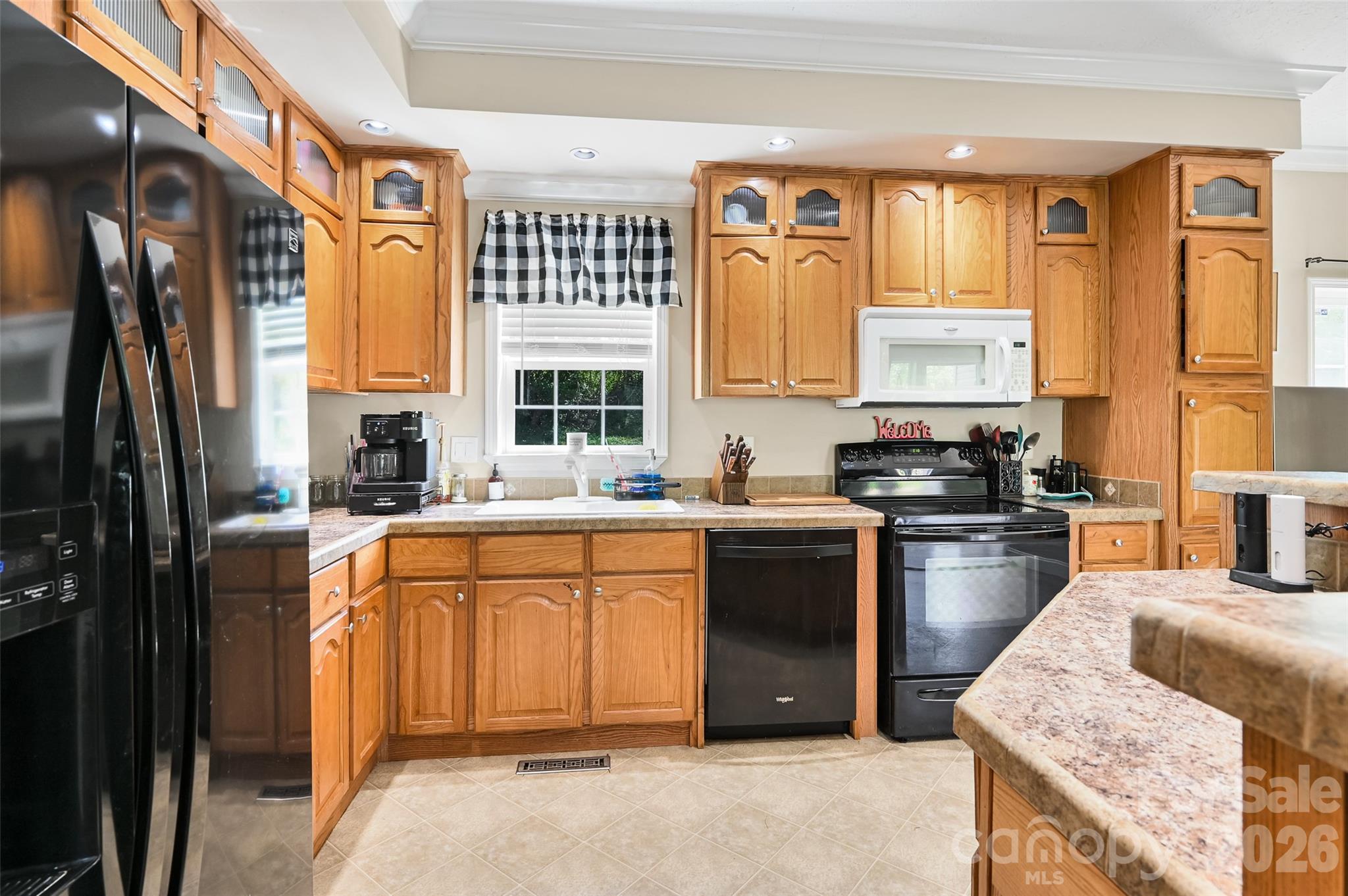 371 Starnes Cove Road Candler, NC 28715 - Photo 7 of 21 a kitchen with stainless steel appliances granite countertop a refrigerator a sink dishwasher a stove and a dining table with wooden floor