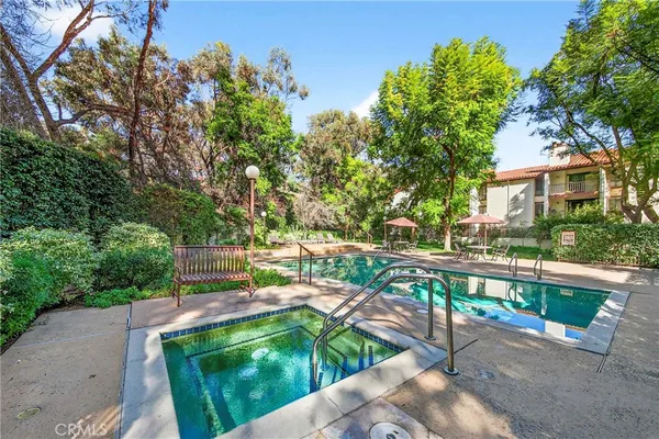 a view of a swimming pool with a patio and garden