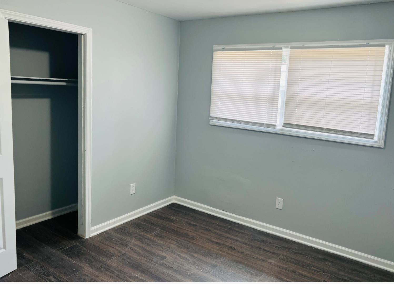 710 Hudson Street Memphis, TN 38112 - Photo 4 of 11 an empty room with wooden floor and windows