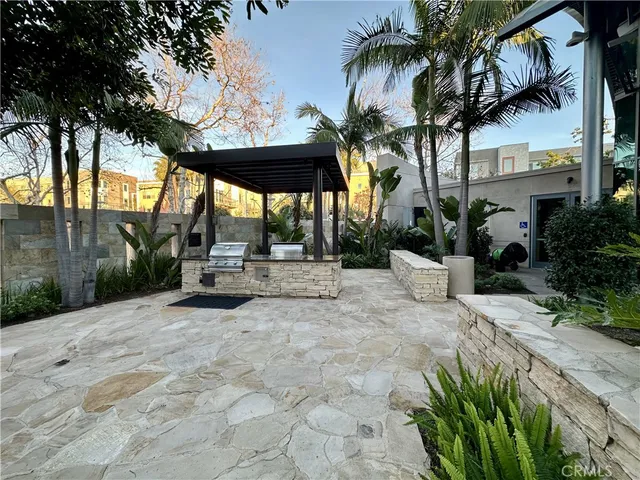 a view of a patio with table and chairs potted plants and palm trees