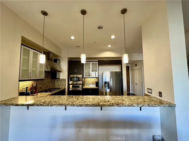 a kitchen with kitchen island granite countertop a sink and a counter top space