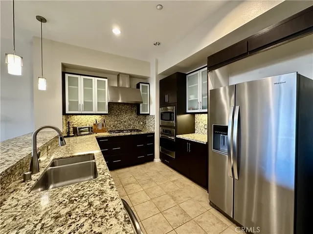 a kitchen with a refrigerator sink and wooden cabinets