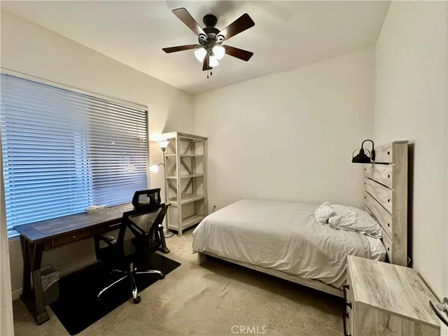 a bedroom with a bed and a ceiling fan