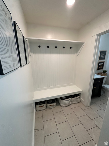 1148 290 South Logan, UT 84321 - Photo 11 of 34 Built-in storage bench with beadboard backing and wall hooks, overhead shelving, and rectangular tile flooring