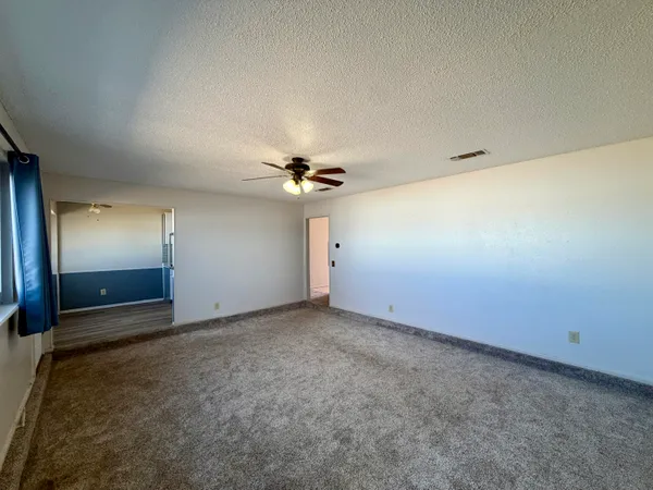 an empty room with a ceiling fan and a window