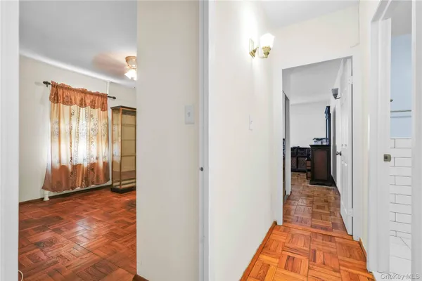 a view of a hallway with wooden floor and a livingroom