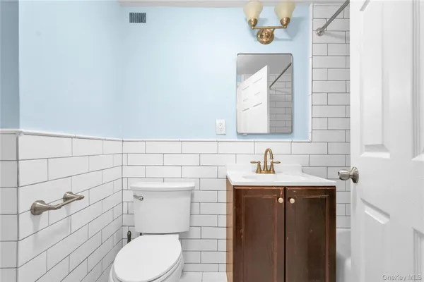 a bathroom with a toilet a sink and mirror