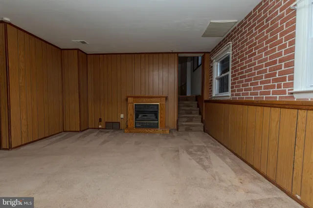 a view of a hallway with wooden floor and a bathroom