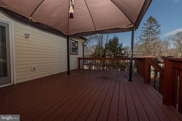 a view of backyard with a deck and barbeque oven