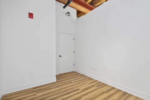 a view of a room with wooden floor and white walls