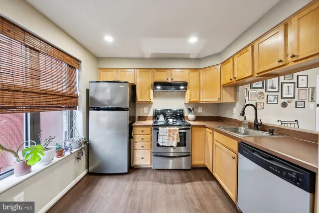 a kitchen with stainless steel appliances a stove a sink and a refrigerator