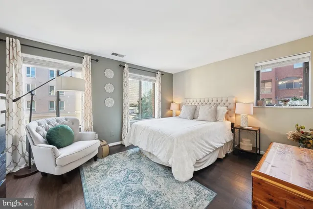 a spacious bedroom with a bed and glass window