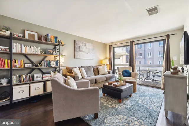 a living room with furniture and a book shelf