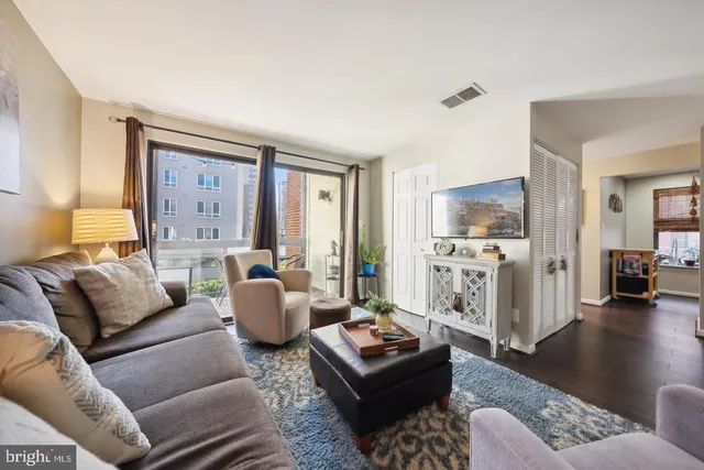 a living room with furniture and a wooden floor