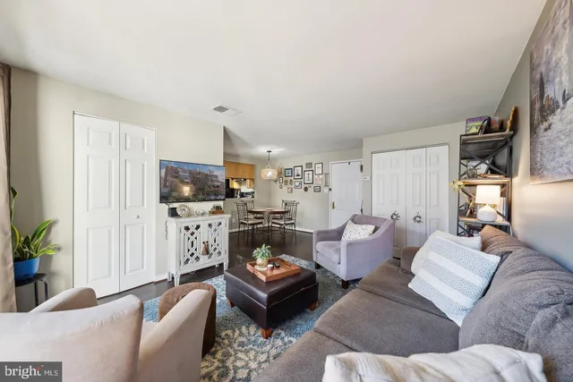 a living room with furniture kitchen view and a window