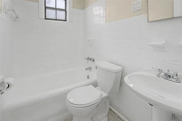 a white toilet sitting next to a bath tub