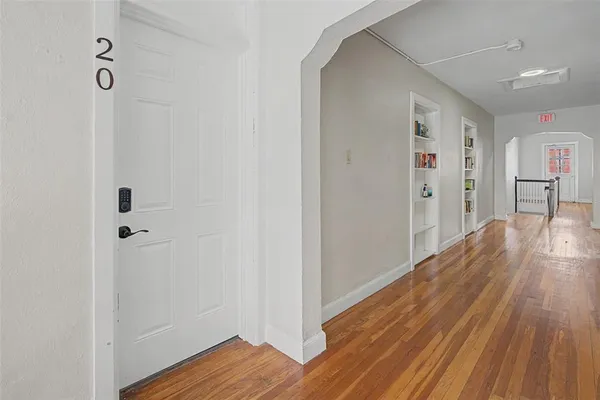 a view of a hallway with wooden floor