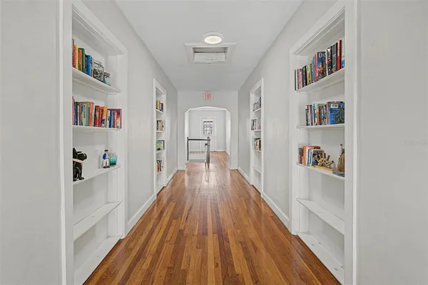 a view of a hallway with wooden floor and dining room