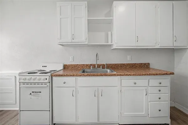 a kitchen with granite countertop white cabinets and white appliances