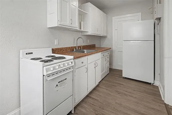 a kitchen with white cabinets and white appliances