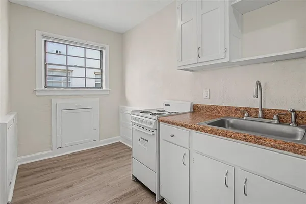 a kitchen with granite countertop white cabinets and a sink