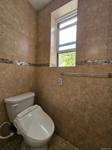 a white toilet sitting next to a window
