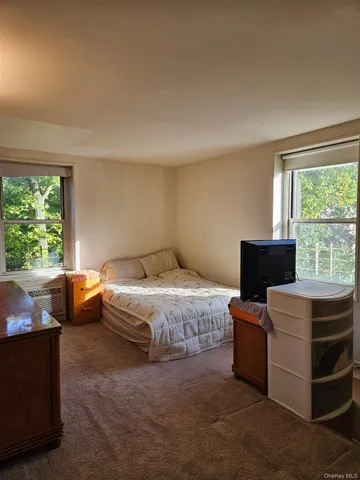 a spacious bedroom with a bed and a window