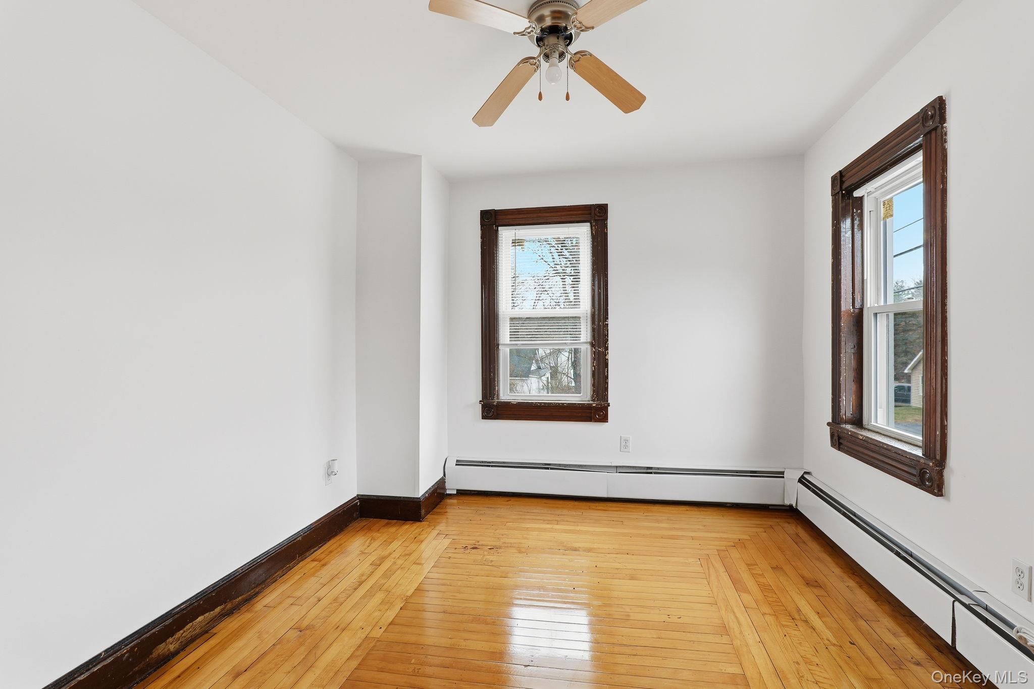 708 Burlingham Road Bloomingburg, NY 12721 - Photo 11 of 25 Unfurnished room featuring a baseboard radiator, light wood-type flooring, and a ceiling fan