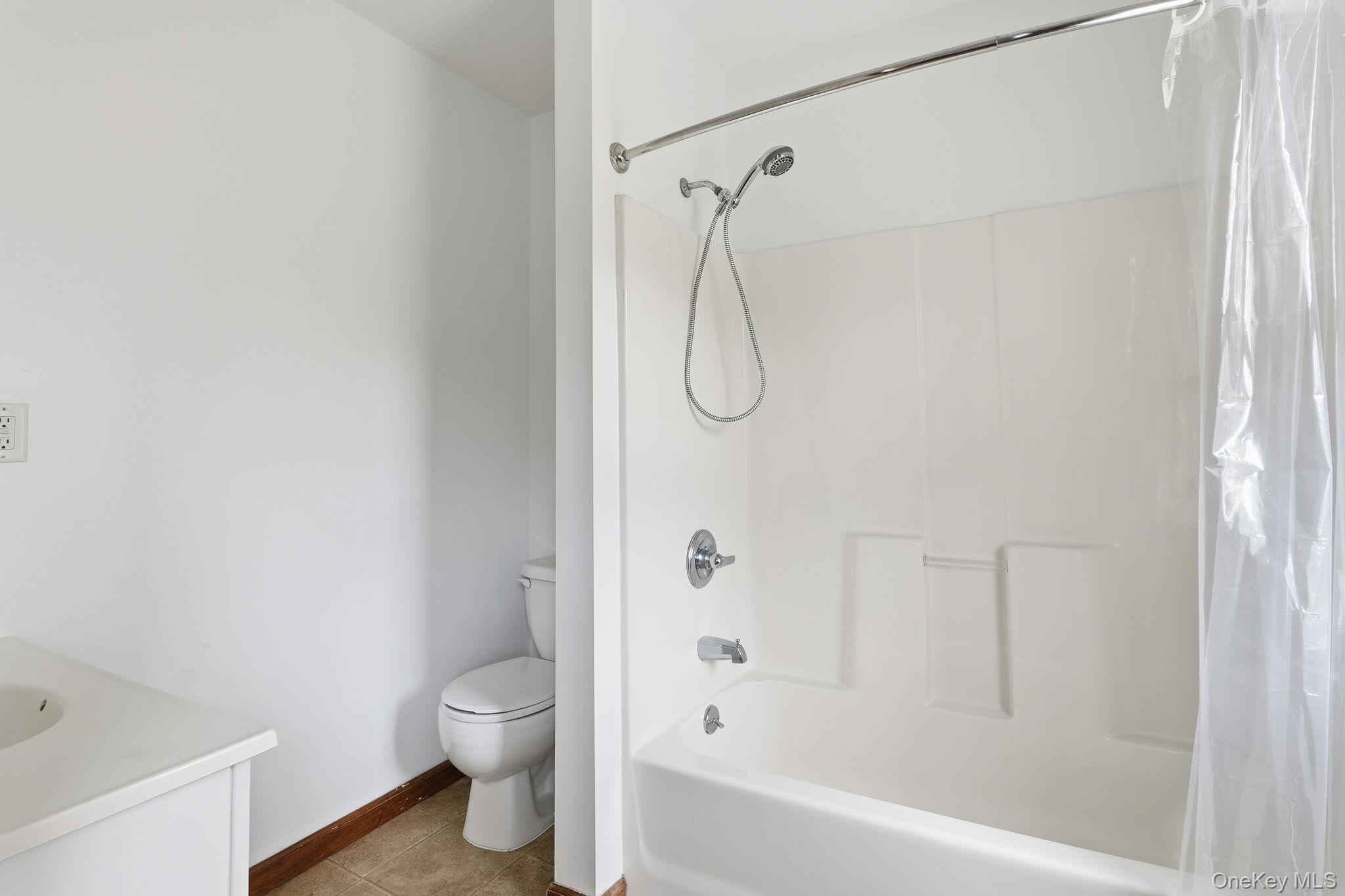 708 Burlingham Road Bloomingburg, NY 12721 - Photo 18 of 25 Bathroom with vanity, shower / bath combo with shower curtain, and light tile patterned flooring