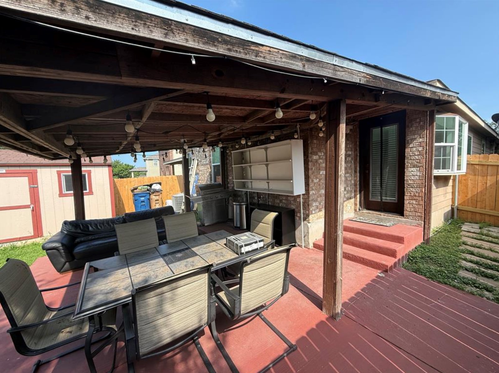 6600 Glebe Path Austin, TX 78754 - Photo 11 of 11 An inviting outdoor living space features a covered patio with string lighting and a separate storage shed.