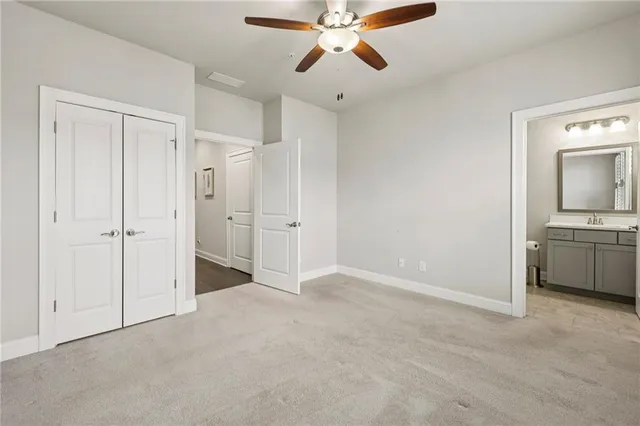 a view of a room with a ceiling fan and a bathroom
