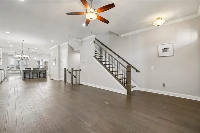 a view of a livingroom with wooden floor and a ceiling fan