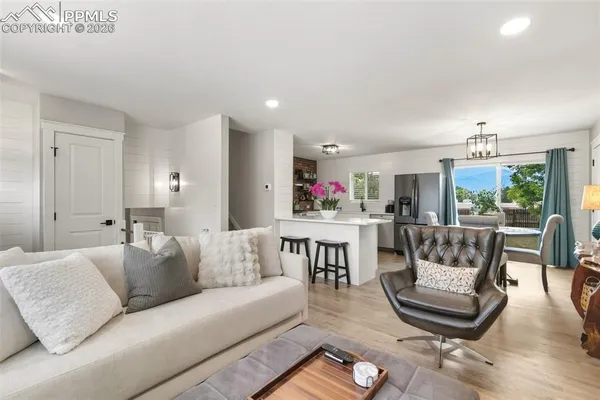 a living room with furniture and a dining table with kitchen view