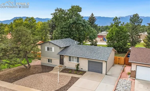 aerial view of a house with a yard and tree s