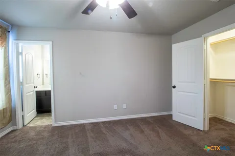 an empty room with closet and windows