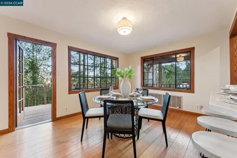 a dining room with furniture a chandelier and wooden floor
