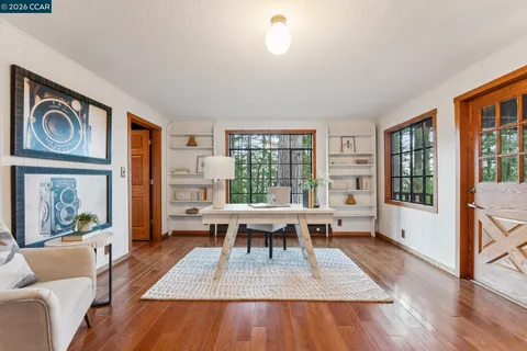 a living room with furniture a wooden floor and a large window