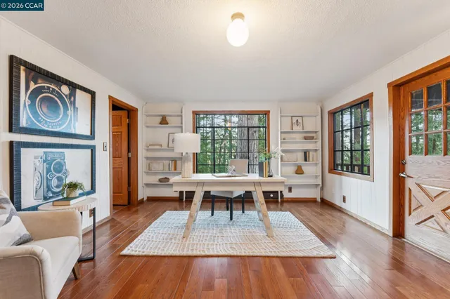 a living room with furniture a wooden floor and a large window